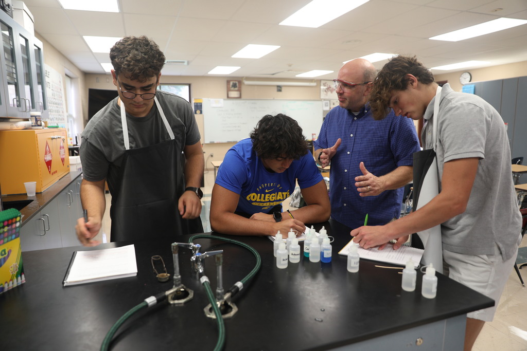 Chemistry Teacher explains chemical reactions to small group